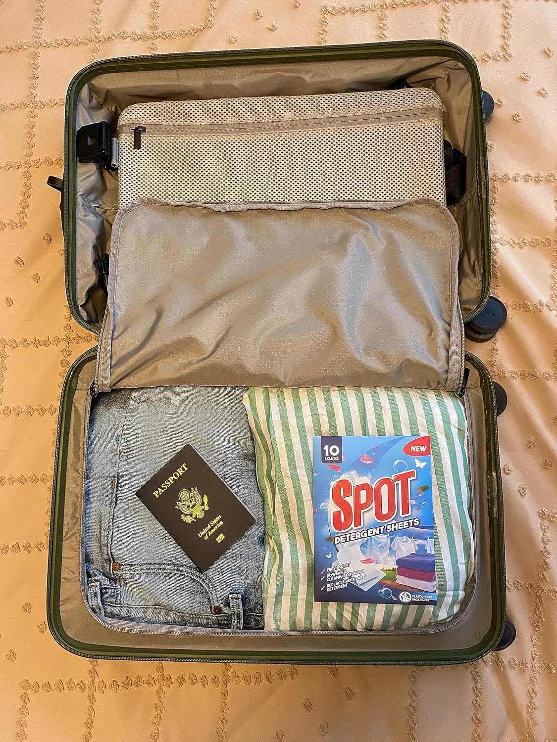 Spot pack in a carry-on suitcase next to a passport
